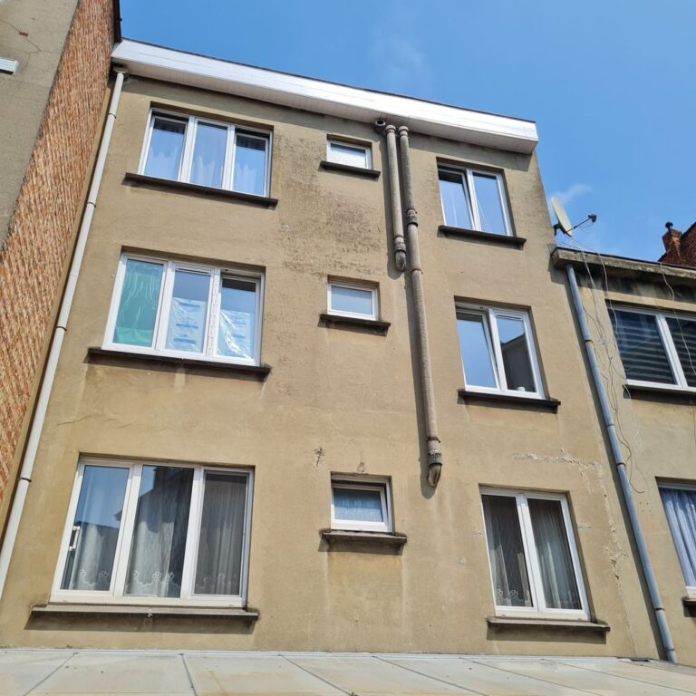 Façade d'immeuble rénovée avec un crépi beige