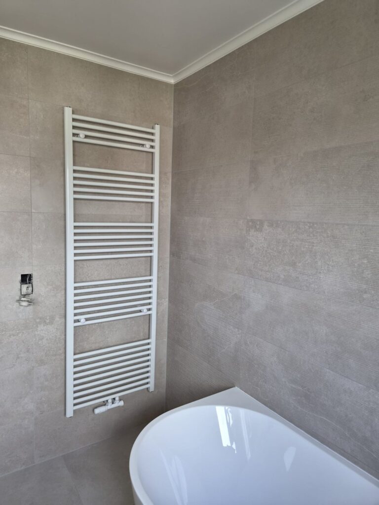 Salle de bain avec sèche-serviette et baignoire îlot
