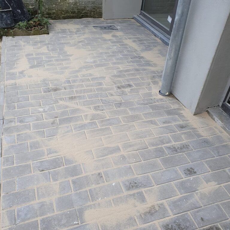 Terrasse en klinkers posée devant une baie vitrée